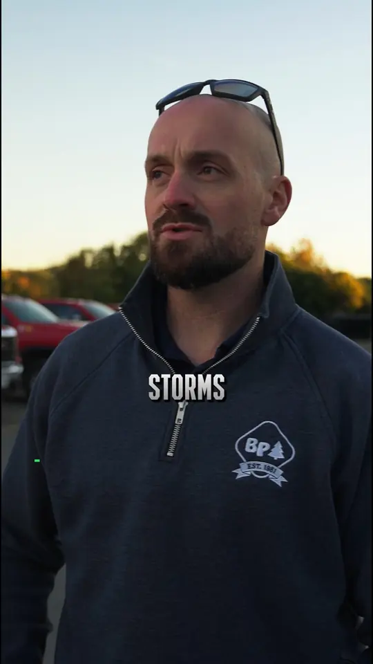 A BP Landscaping team member outdoors at dusk discussing winter storm response.